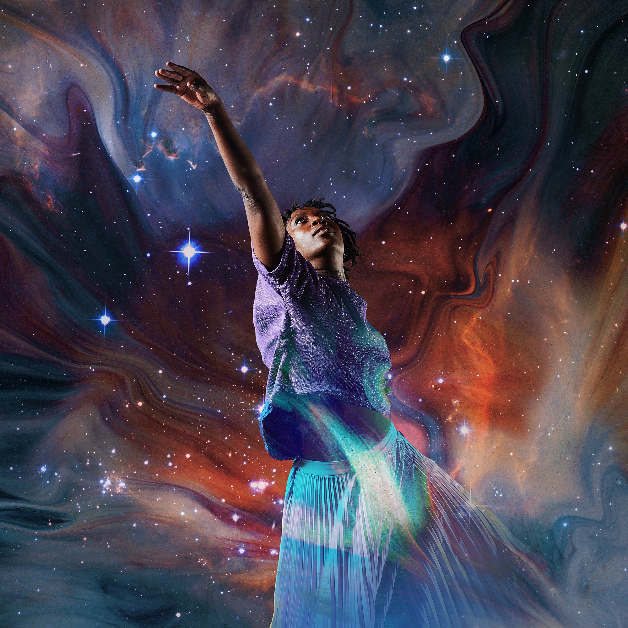 A black female dancer reaches into the stars as a swirling galaxy surrounds her