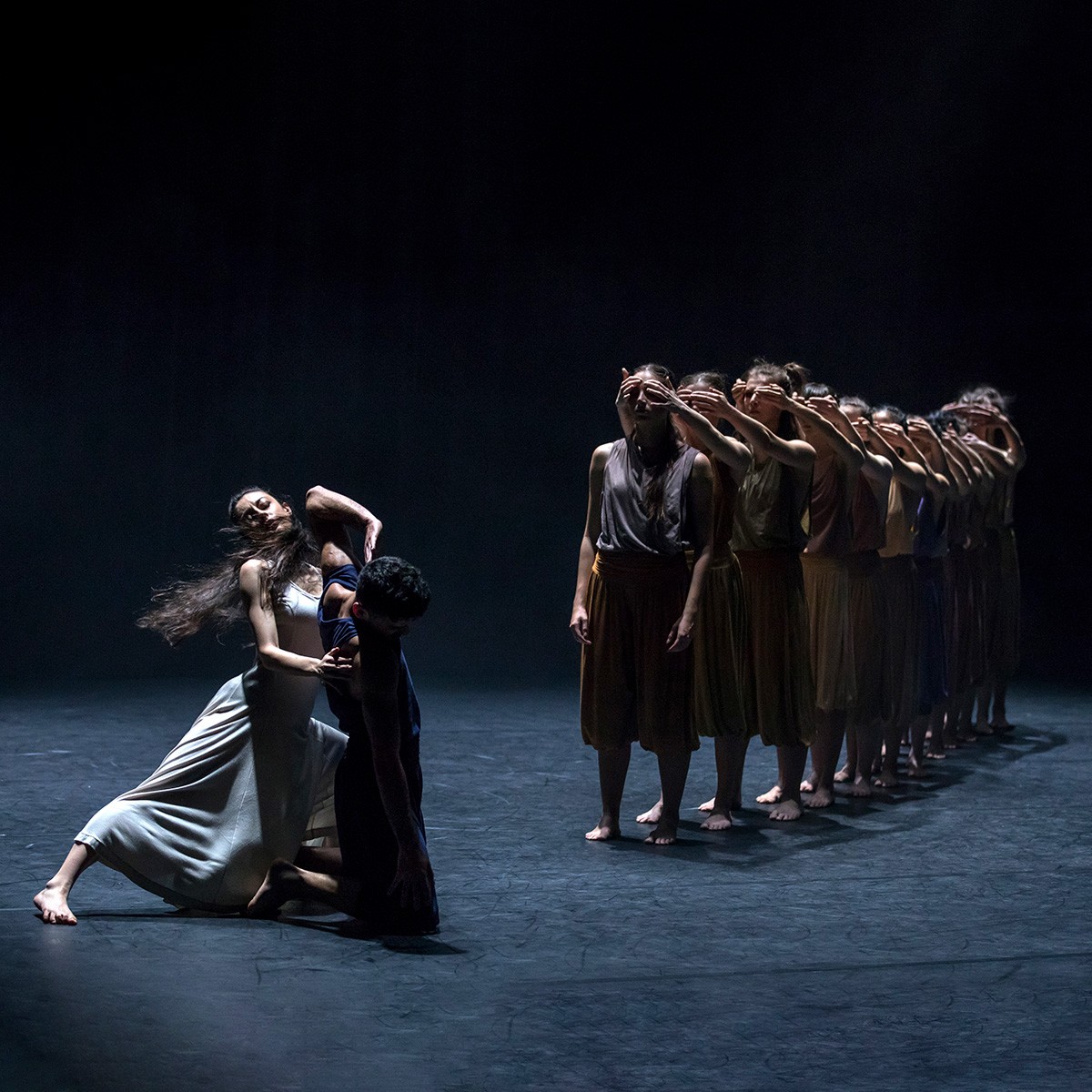 Group of dancers in line covering their eyes