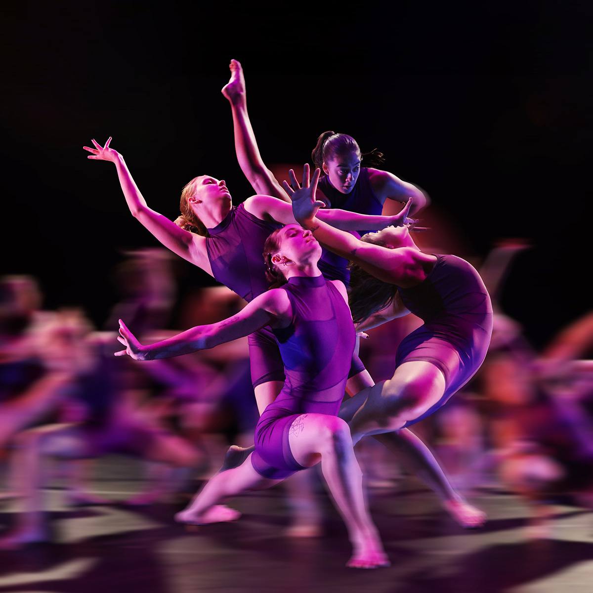 Blurry image of group of dancers in purple costumes 